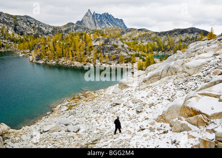 La vista di una donna scende da un astragalo campo verso il lago di ispirazione con picco Prusik a distanza, un incantesimo Laghi Foto Stock