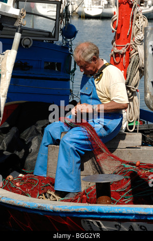 Fisherman riassettavano le reti per i pescatori's Quay, Île de Porquerolles o isola, Îles d'Hyères, Var, Côte d'Azur, in Francia Foto Stock