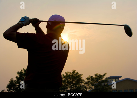 Silhouette di un giocatore di golf al tramonto Foto Stock