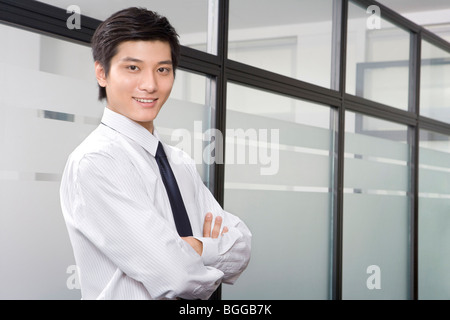 Giovane imprenditore facendo pollice in su in ufficio Foto Stock