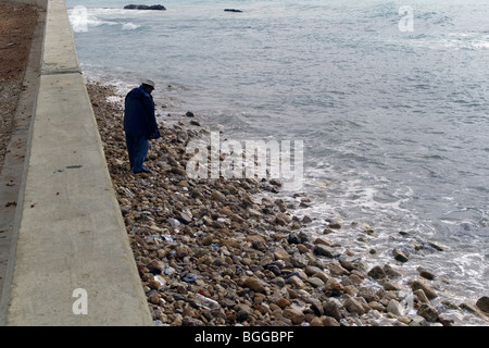 Uomo che cammina lungo la costa al di sotto della Corniche al pneumatico, Libano Foto Stock