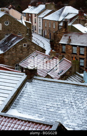 Inverno Meteo & neve tetti coperti. La coperta di neve piastrellate tetti rossi delle case dei pescatori in Staithes, North Yorkshire National Park, Regno Unito Foto Stock