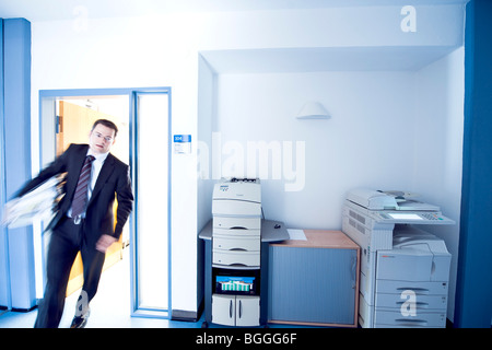 Imprenditore oberato di lavoro entrando in una stanza, offuscata motion, vista frontale Foto Stock