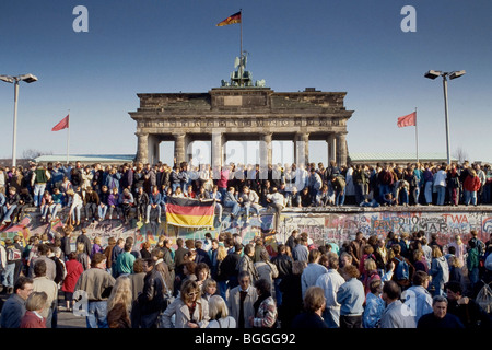 Caduta del muro di Berlino: persone da Berlino Ovest e Berlino Est salendo sulla parete presso la Porta di Brandeburgo, Berlino, Germania Foto Stock