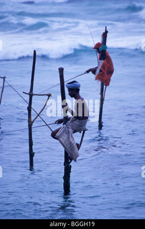 Stilt pescatori nell'oceano, Weligama, Sri Lanka Foto Stock