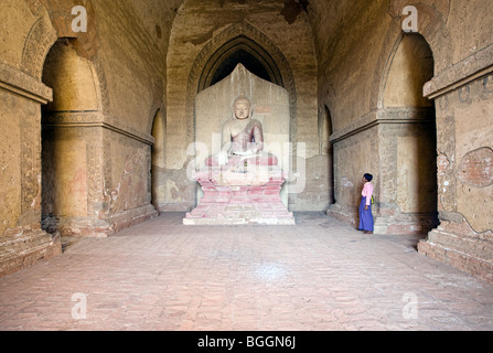 Ragazzo contemplando la statua di Buddha. Dhammayangyi Tempio. Bagan. Myanmar Foto Stock