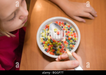 Dieci anni di vecchia ragazza mangiare cereali zucchero a casa, ad alto angolo di visione Foto Stock