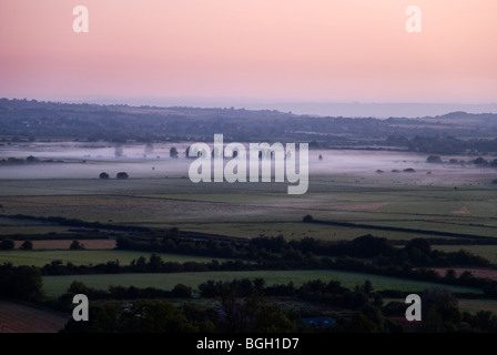 Sunrise a Burrow hill Somerset guardando oltre i livelli di Somerset. Foto Stock