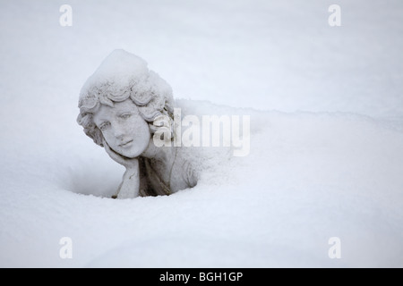 Statua femminile in gran parte ricoperta di neve Foto Stock