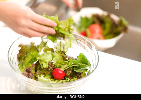 Donna fare insalata Foto Stock