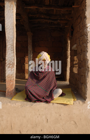 Rajasthani vecchio seduto su una coperta indossando turbante Foto Stock