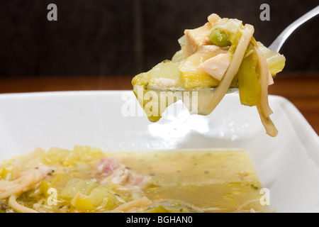 Home abbondante di brodo di cottura realizzato da avanzi di Turchia, prosciutto, porri, tagliatelle e piselli. Foto Stock