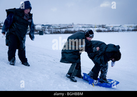 Tre ragazzi giocare nella neve. Hafnarfjordur, una maggiore area di Reykjavik, Islanda. Foto Stock