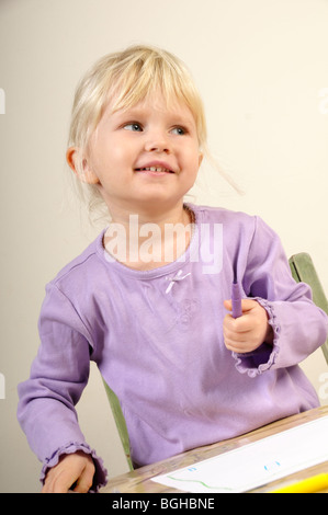 Foto di stock di un 4 anno vecchia ragazza foto di disegno su un pezzo di carta. Foto Stock