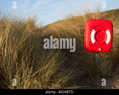 Un rosso brillante salvagente sulla spiaggia a Aberdovey (Aberdyfi), Gwynedd Mid Wales UK Foto Stock