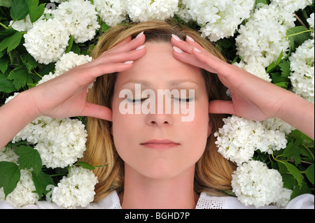 Giovane donna posa in fiori - snowballs Foto Stock