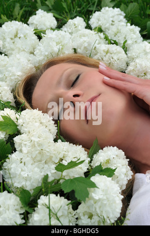 Giovane donna posa in fiori - snowballs Foto Stock