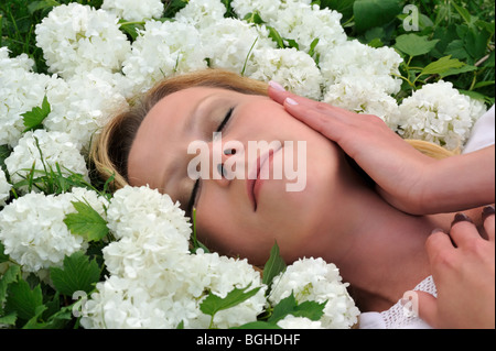 Giovane donna posa in fiori - snowballs Foto Stock