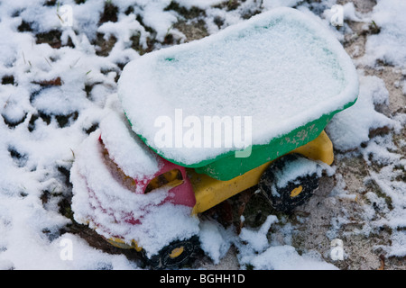 Giocattolo di plastica carrello coperte di neve in giardino Foto Stock