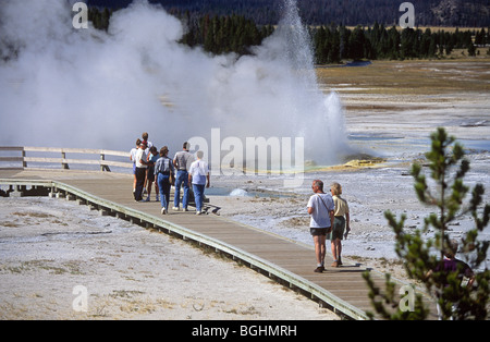 I turisti a piedi attraverso un geyser basin vicino alla vecchia fedeli, nel Parco Nazionale di Yellowstone Foto Stock