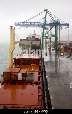 Le navi portacontainer a fianco di quay in un giorno di pioggia Foto Stock