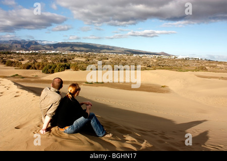 Un giovane godendo la vista sulle dune di sabbia di Maspalomas, guardando verso le lontane località di Playa del Ingles Foto Stock