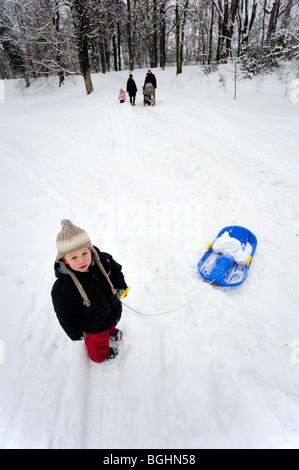 Bambino ragazzo neve invernale slittino in posizione di parcheggio Foto Stock