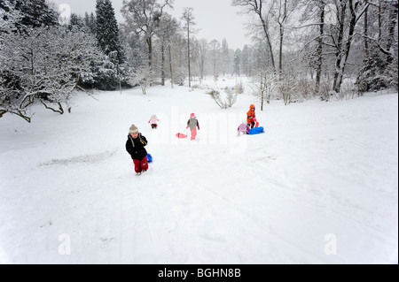 Bambino ragazzo neve invernale slittino in posizione di parcheggio Foto Stock