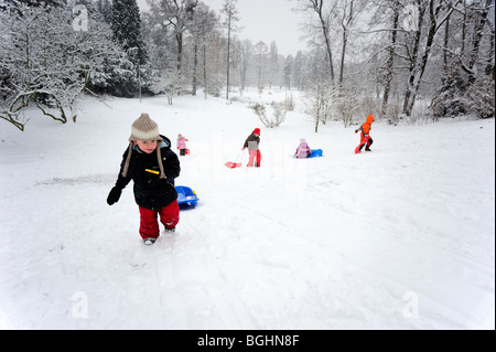 Bambino ragazzo neve invernale slittino in posizione di parcheggio Foto Stock