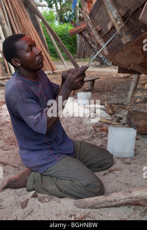 Zanzibar, Tanzania. Carpenter la costruzione di una Dhow. Segare per effettuare una migliore vestibilità. Foto Stock