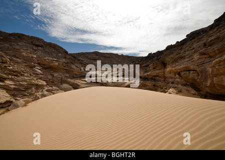 Increspata dune di sabbia che conduce al colle roccioso del Deserto Orientale di Egitto Foto Stock