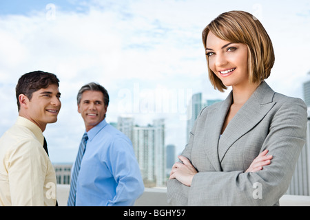 Imprenditrice e i suoi due maschi subordinati. Foto Stock