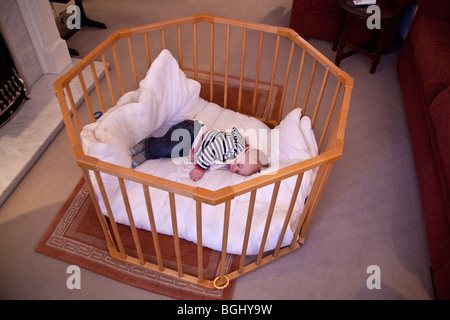 Baby boy otto mesi, dormendo in un box per bambini. Foto Stock