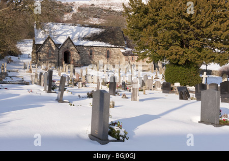 Coperta di neve piccolo villaggio chiesa e cimitero in ambiente rurale Foto Stock