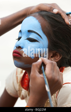 Ragazza indiana avente il suo volto dipinto di blu per essere costituita come una divinità in India. Andhra Pradesh, India Foto Stock