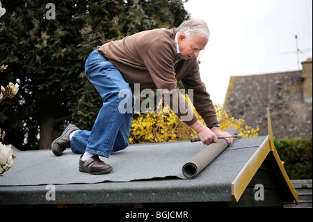 Un uomo in pensione re-feltri a shed UK Foto Stock