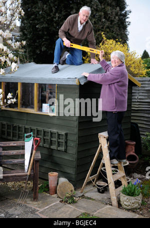 Due pensionati ri-feltri a shed UK Foto Stock