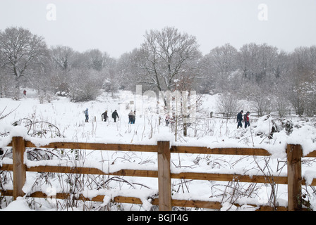I gruppi della famiglia camminare su strade coperte di neve campo. Grande neve caduta A3 area di hampshire gennaio 2010 Foto Stock