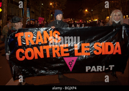 Parigi, Francia, attivisti di AIDS Transgenres di pari-T e di altri gruppi LGBT, proteste contro l'AIDS al 1 dicembre "Giornata mondiale contro l'AIDS" Marching, Holding protest Banner on Street at night "Trans against AIDS" Foto Stock