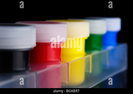 Tubi colorati di vernice acrilica isolati su sfondo nero Foto Stock