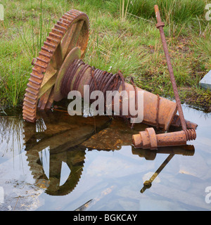 Parte di un meccanismo di avvolgimento giace la ruggine nelle acque di Llyn Cwmorthin cava di ardesia vicino a Blaenau Ffestiniog nel Galles del Nord Foto Stock