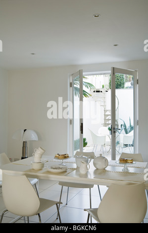 Area pranzo nel rinnovato Il Grade ii Listed Townhouse Brighton con finestre francesi e una scala a spirale. Foto Stock