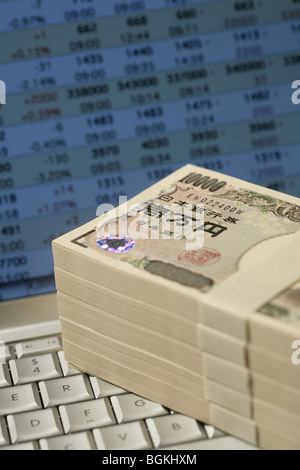 Fasci di 10 000 yen note sulla tastiera di un computer Foto Stock