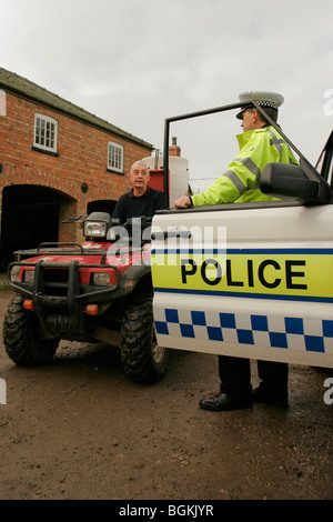 Funzionario di polizia di parlare ad un agricoltore Foto Stock