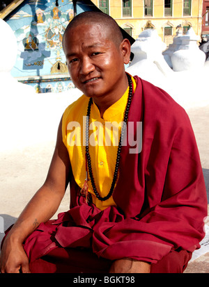 Monaco buddista seduto fuori Bodhnath Stupa Kathmandu in Nepal Asia Foto Stock