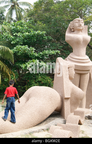 Ragazzo in piedi in una bella statua in Veli Villaggio turistico Foto Stock