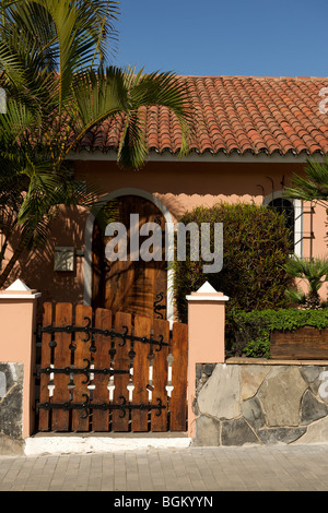 Casa canarica rosa salmone con porta in legno ad arco, tetto a tegole e cancello da giardino in legno, Puerto de la Cruz, Tenerife, Spagna Foto Stock