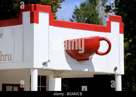Denver in Colorado. Buzz Cafe in un convertito gas di riempimento della stazione di servizio ha un gigante rosso tazza da caffè mug sporgenti dalla parete. Foto Stock