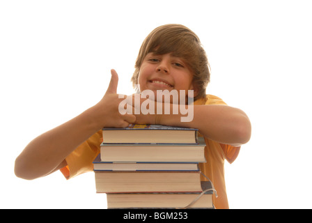 Il ragazzo, 16, appoggiata su una pila di libri, cercando felice, pollice in alto Foto Stock