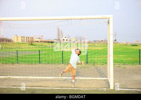 Ragazzo giovane goalkeeping sul campo. Futako-tamagawa, Setagaya-ku, Prefettura di Tokyo, Giappone Foto Stock